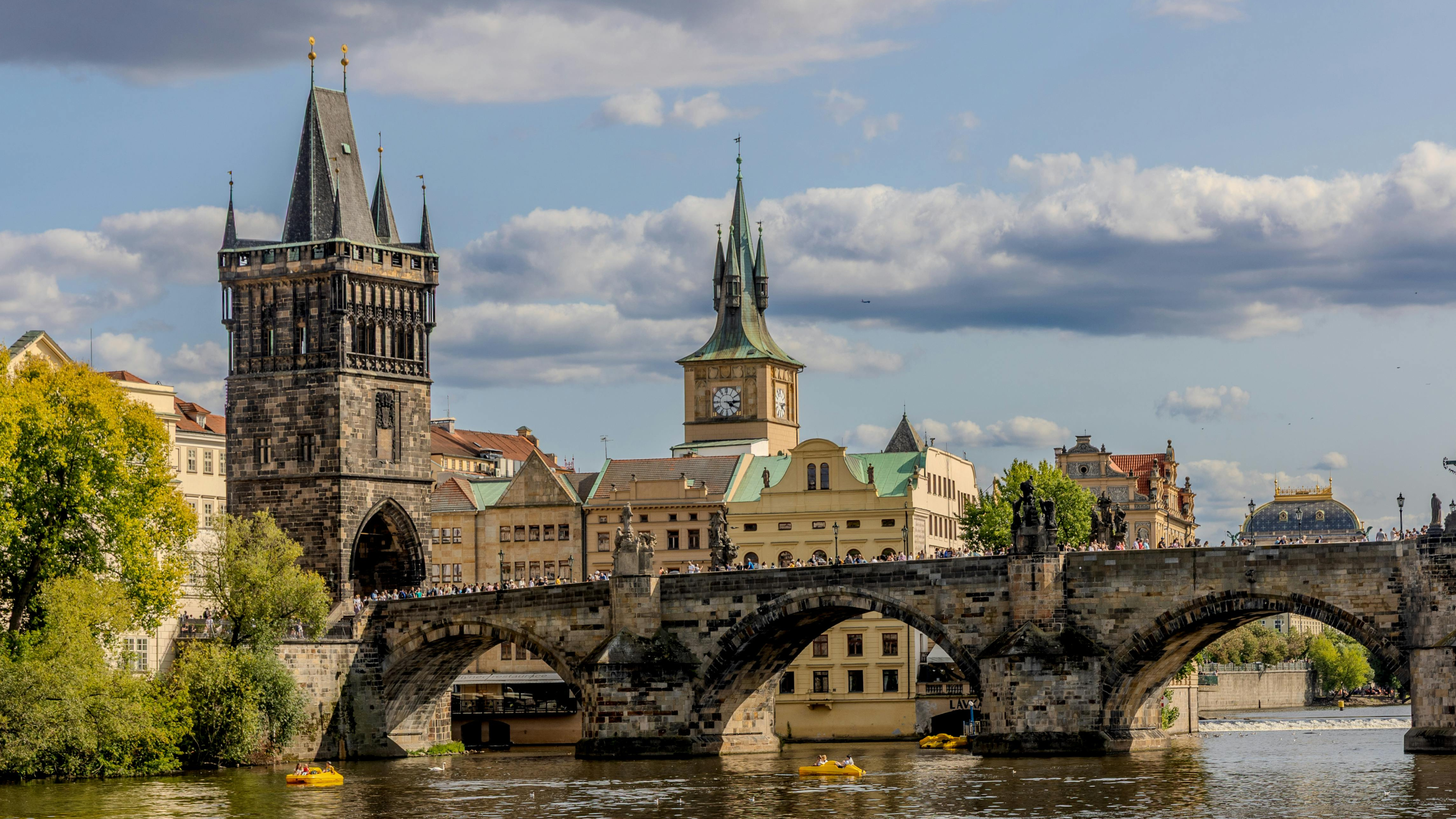 Charles Bridge and Old Town Tower spanning the Vltava River in Prague, Czech Republic — European roadshow destination