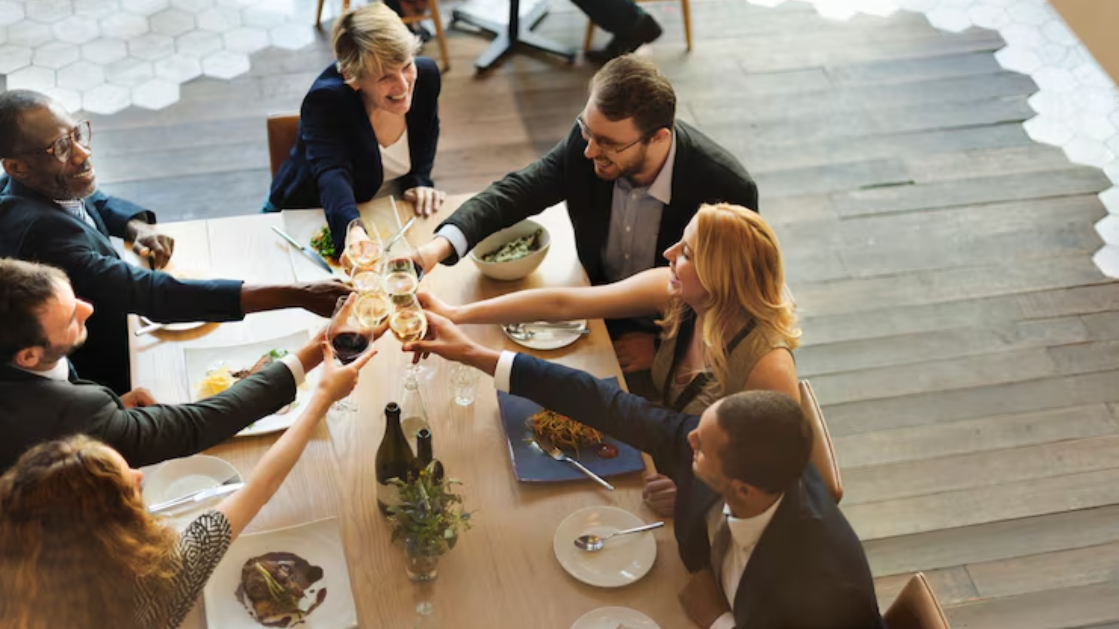 Business professionals toasting at a dining table during an executive retreat dinner