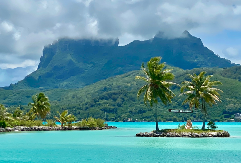 Overwater bungalows on a turquoise lagoon with Mount Otemanu in the background, Bora Bora, French Polynesia