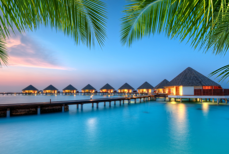 Overwater villa bungalows with private pool steps leading into a turquoise lagoon, Maldives luxury resort